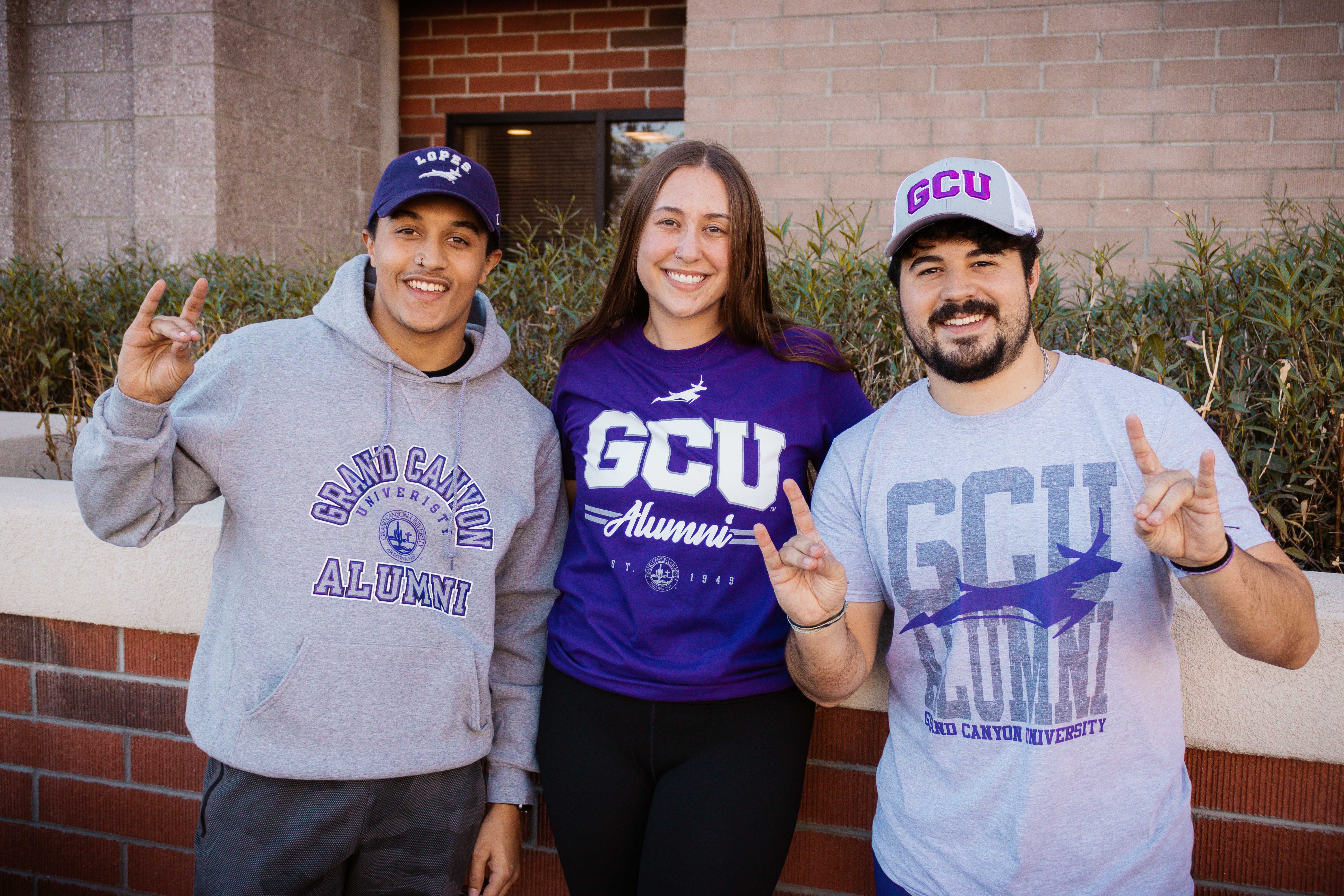 three GCU Alumni in different GCU alumni gear