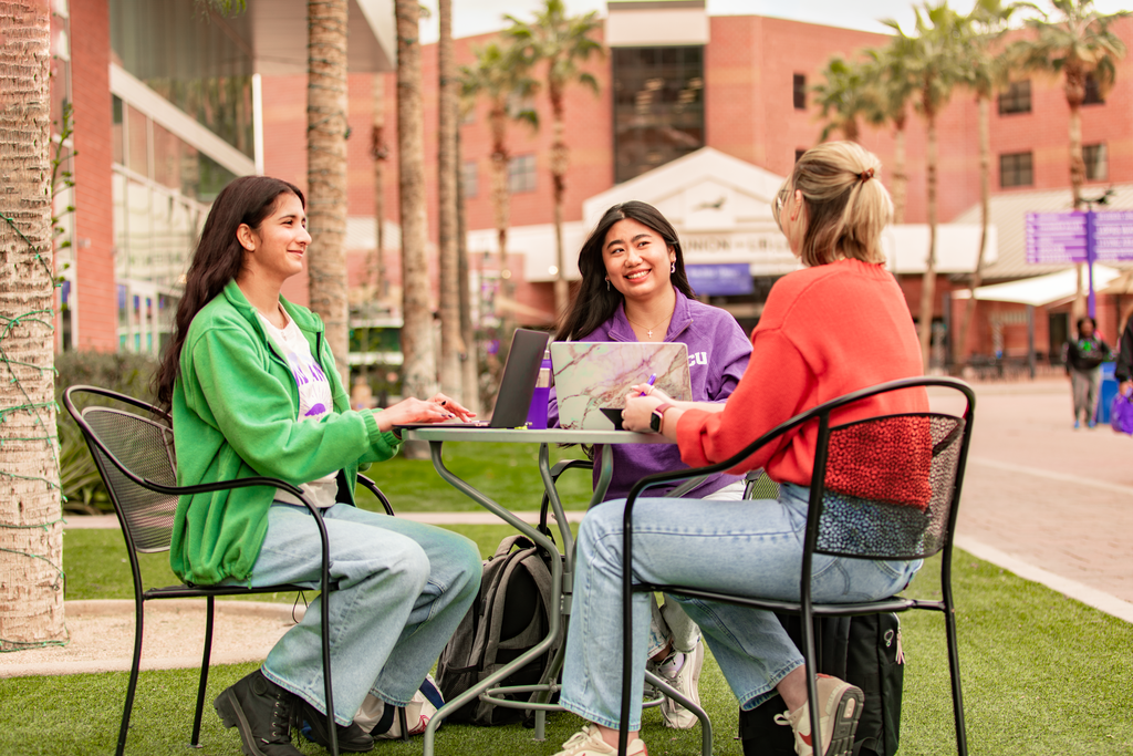 Students studying around a table outside on GCU campus