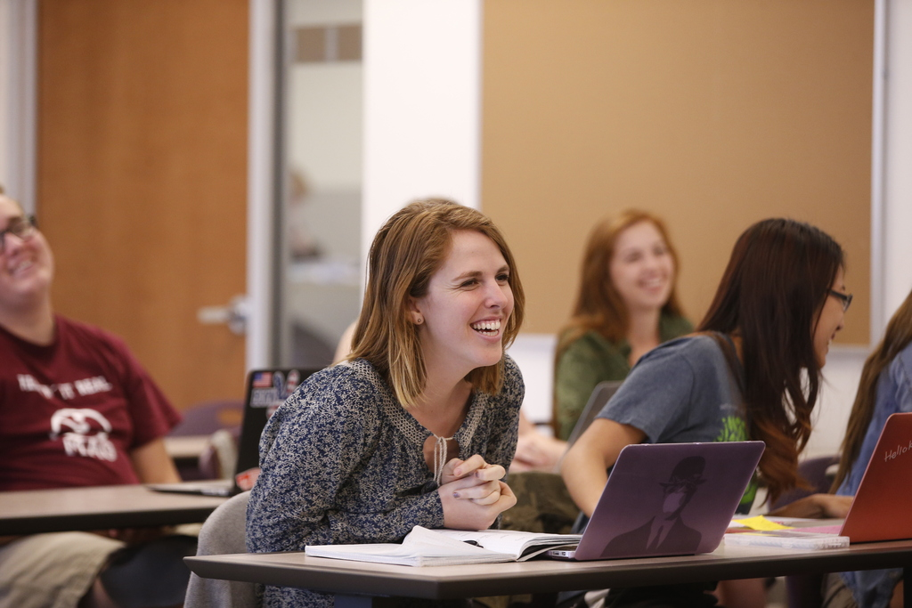 Student laughing in traditional classroom setting