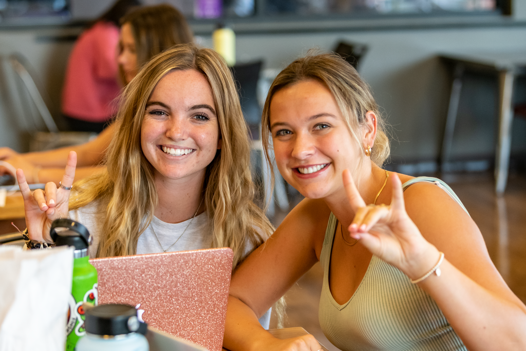 Students giving the Lopes Up hand symbol on campus