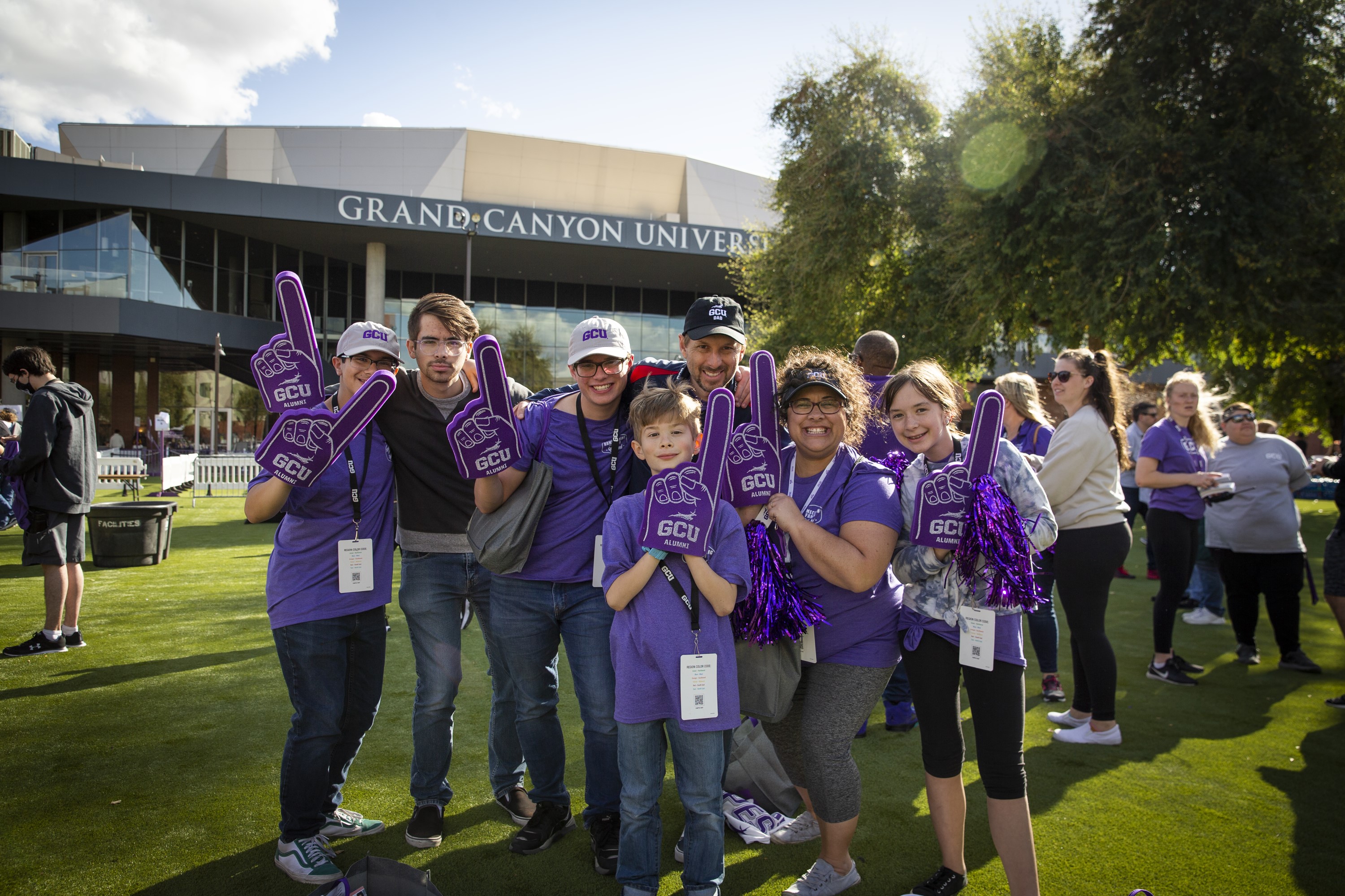Family holding up foam fingers on the lawn during Family Weekend
