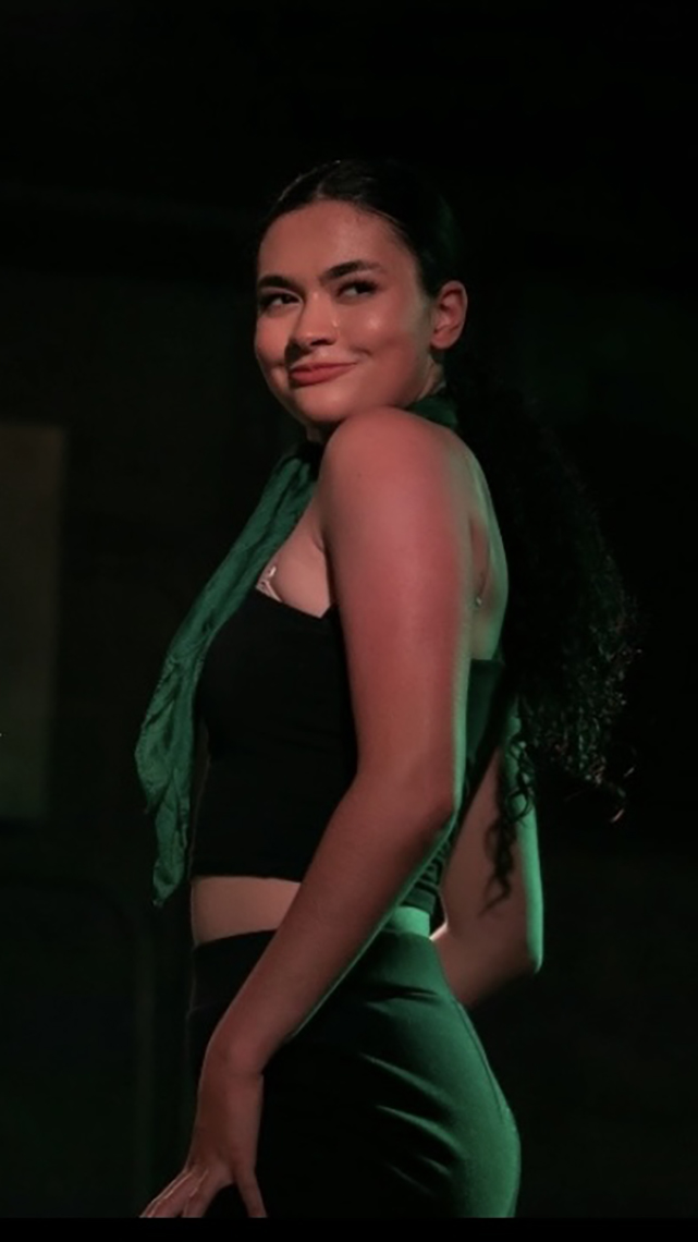Closeup of Jordan in a performance with green spotlights on her