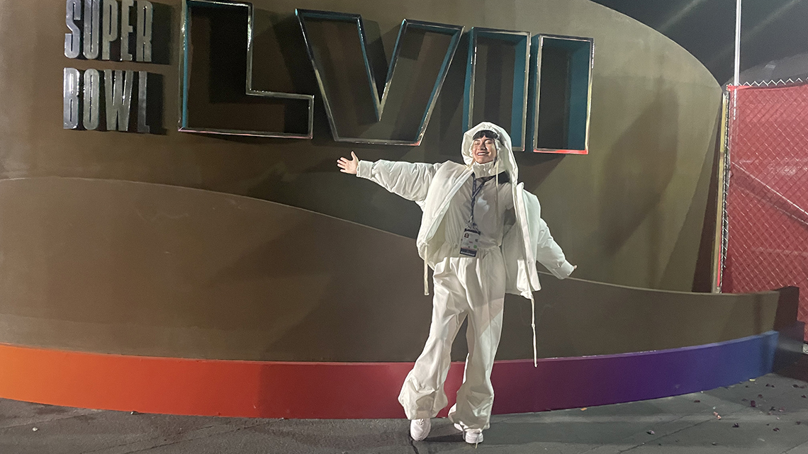 Jordan in all white in front of Superbowl 57 signage in 2022