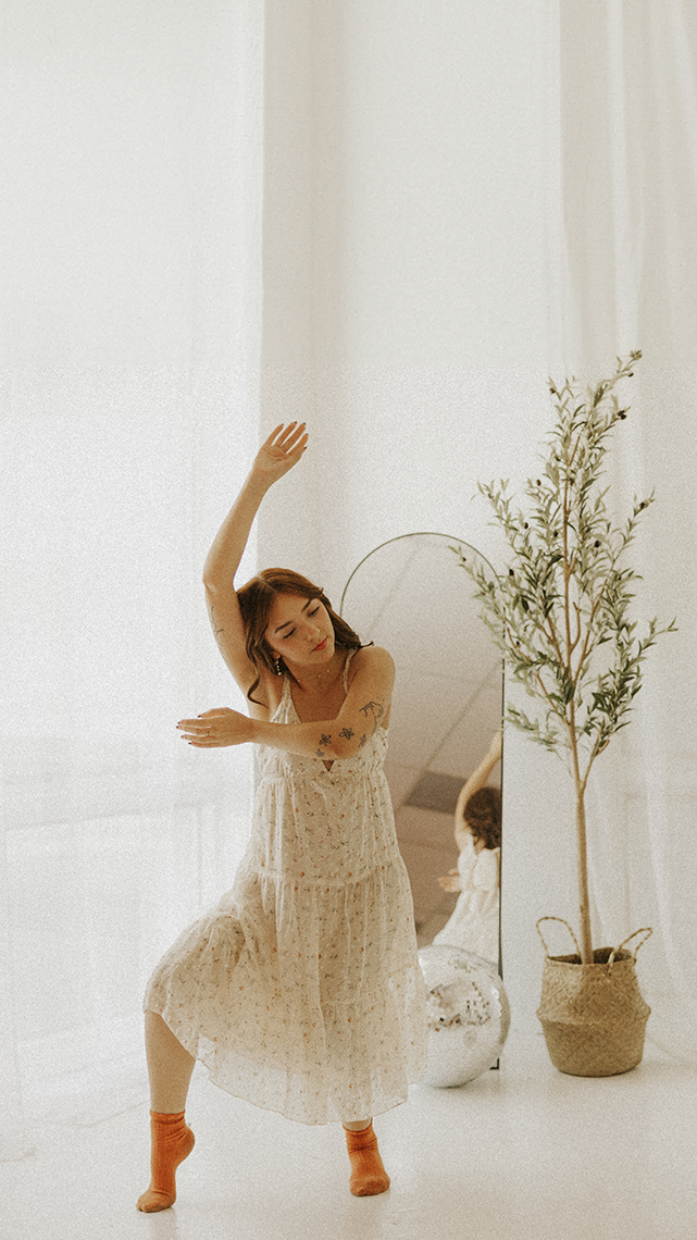 Girl in white sun dress in a modified pointe ballet dance move